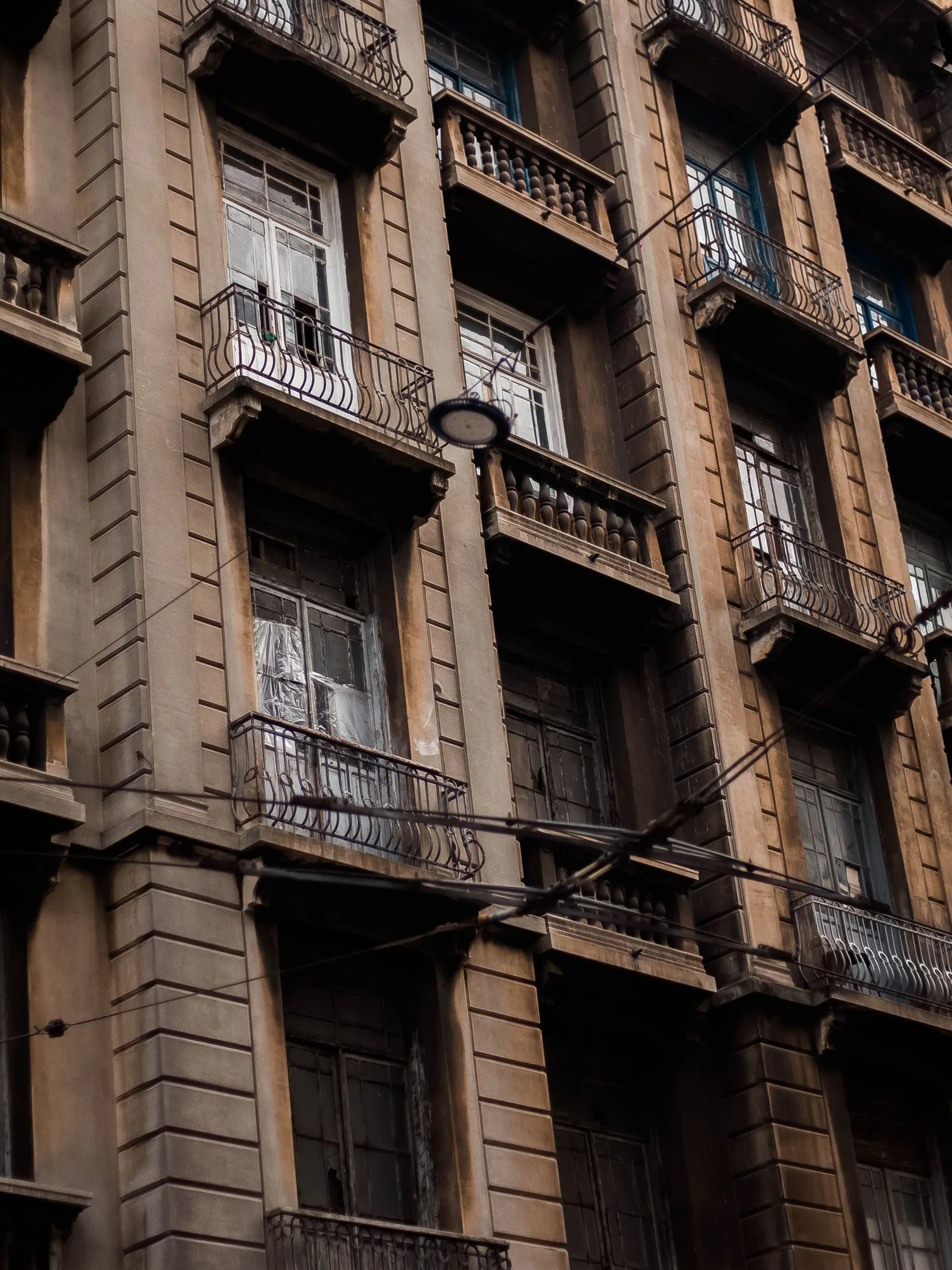 Façade d’un immeuble ancien à balcons, vue en contre-plongée